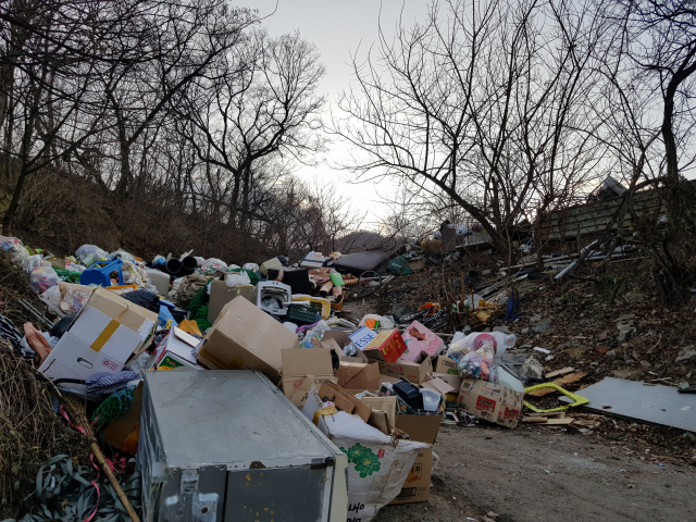 20일 오전 부산 금정구 노포동 금정산 외곽 산자락 일대 그린벨트 지역에 수백t가량의 폐기물이 쌓여 ‘쓰레기 언덕’을 이루고 있다.