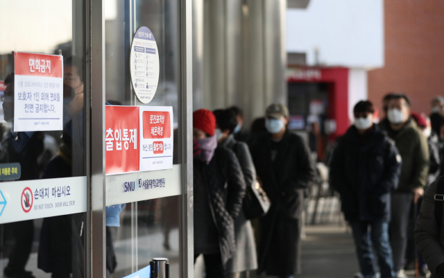 1월 31일 서울 종로구 서울대병원을 찾은 시민들이 병원 출입에 필요한 체온 측정과 문진서 작성을 위해 줄지어 기다리고 있다. 연합뉴스.