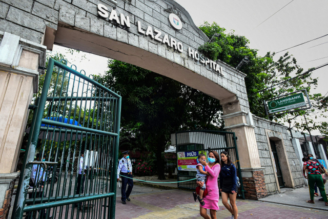 2일(현지시간) 필리핀 마닐라의 산라자로 병원 입구에 마스크를 쓴 관계자들이 서 있다. AFP연합뉴스