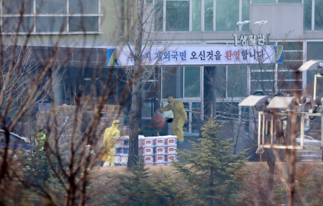 2일 오전 우한 교민이 생활하는 충남 아산 경찰인재개발원 생활관 입구에서 방역 당국 관계자들이 구호물품을 쌓아두고 분주하게 움직이고 있다. 연합뉴스