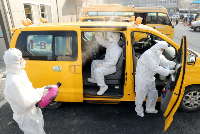 11일 부산 동래구청 임시청사 주차장에서 구청 직원들이 신종 코로나 바이러스 감염증 확산 예방을 위해 지역 내 어린이집 통학차량에 대한 실내소독을 하고 있다. 강원태 기자 wkang@