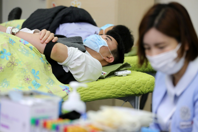 12일 부산시청 대회의실에서 열린 ‘부산시 직원 헌혈의 날’ 행사에 참여한 공무원들이 마스크를 쓰고 헌혈을 하고 있다. 신종 코로나바이러스 감염증 여파로 헌혈이 급격히 줄면서 부산시는 당초 3월에 시행할 예정이었던 직원 헌혈의 날을 앞당겨 시행했다. 김경현 기자 view@