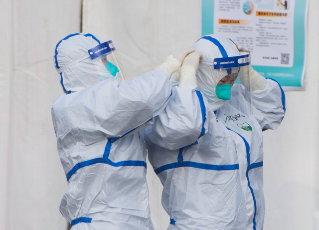 코로나19와 사투를 벌이고 있는 발원지 중국 후베이성 우한시의 의료진을 지원하기 위해 현장으로 달려온 안후이성 의료진이 12일(현지시간) 임시병원으로 사용되고 있는 우한스포츠센터에서 활동에 들어가기 전 보호장구를 착용하고 있다. 신화연합뉴스