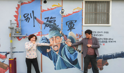 벽화 앞에서 기념사진을 찍는 관광객들.