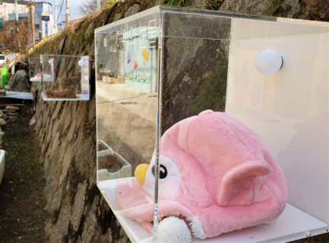 밀양강 둑 벽에 붙은 플라스틱 상자 모양 작품.