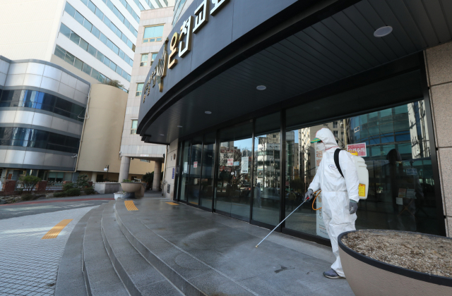 23일 오후 동래구 온천1동 새마을지도자협의회 회원들이 부산 동래구 온천교회 주변을 방역하고 있다. 부산시는 23일 기자회견에서 부산시 확진자 16명 중 부산 1번 확진 환자(19세·남성·동래구)를 포함해 모두 8명이 온천교회와 관련돼 있다고 밝혔다. 정대현 기자 jhyun@