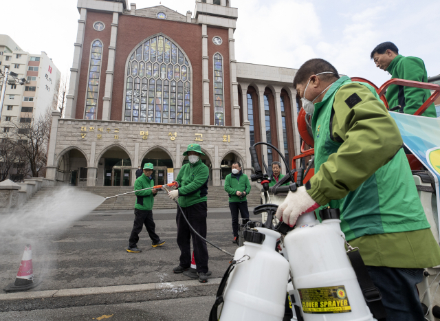 26일 오전 출입 통제 중인 서울 강동구 명성교회 앞에서 관계자들이 소독하고 있다. 연합뉴스