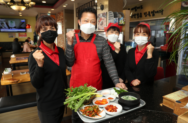 4일 부산 사하구 목촌돼지국밥 박달흠(왼쪽에서 두 번째) 대표와 직원들이 코로나19 확산으로 어려움을 겪고 있는 자영업자들의 위기 극복을 응원하고 있다. 이 식당은 5년 전 메르스 사태 당시 확진자가 다녀간 식당으로 알려져 큰 어려움을 겪었으나 시민과 각계각층의 방문과 격려로 회복할 수 있었다. 정대현 기자 jhyun@