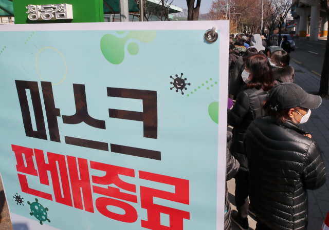 5일 오후 서울 도봉구 하나로마트 창동점에서 시민들이 마스크 판매종료 안내판 뒤로 줄을 서 있다. 연합뉴스