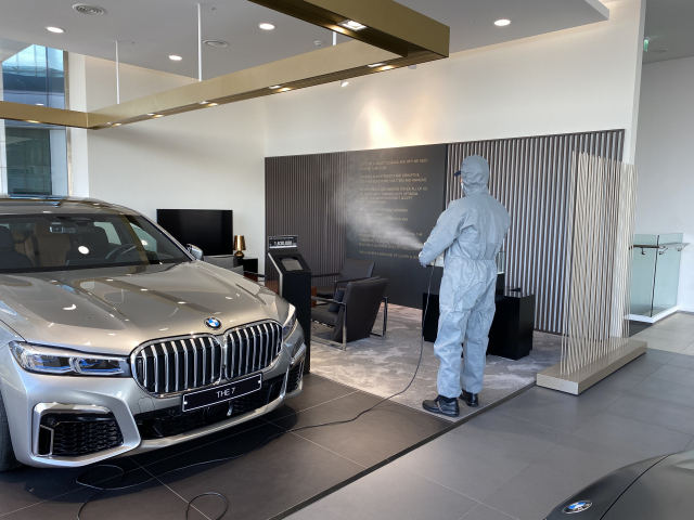 세스코 직원이 BMW 공식딜러 동성모터스 해운대전시장에서 분무기를 이용해 살균작업을 하고 있다.동성모터스 제공
