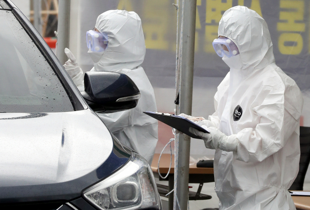 10일 부산시민공원에 설치된 신종 코로나바이러스(코로나19) 드라이브 스루 선별진료소에서 의료진이 문진표를 작성하고 있다. 연합뉴스.