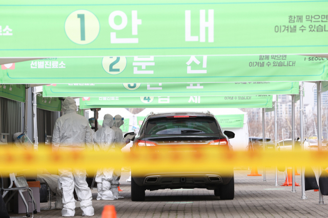 12일 오전 서울 송파구 잠실종합운동장에 설치된 신종 코로나바이러스(코로나19) 드라이브 스루 선별진료소에서 의료진이 검진을 하고 있다. 연합뉴스