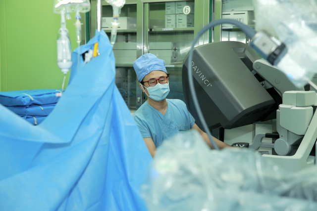 부산대병원 서동수 교수가 4세대 수술 로봇인 다빈치 Xi 를 이용해 자궁경부암 수술을 집도하고 있다. 로봇을 이용한 복강경 수술은 수술 시간과 통증, 합병증을 줄이는 등 장점이 크다. 부산대병원 제공