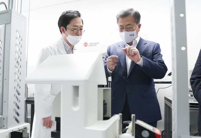 문재인 대통령이 9일 오전 경기도 성남시 한국파스퇴르연구소에서 열린 코로나19 치료제·백신 개발 산업계·학계·연구소·의료계 합동 회의에 앞서 연구시설에서 이홍근 선임연구원으로부터 화합물 처리 과정에 대한 설명을 듣고 있다. 연합뉴스