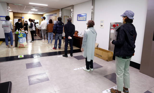 4.15 총선 사전투표 이틀째인 11일 오전 부산 수영구청에 마련된 투표소에서 유권자들이 코로나19 예방을 위해 1m 이상 간격을 유지한 채 투표를 기다리고 있다. 정종회 기자 jjh@