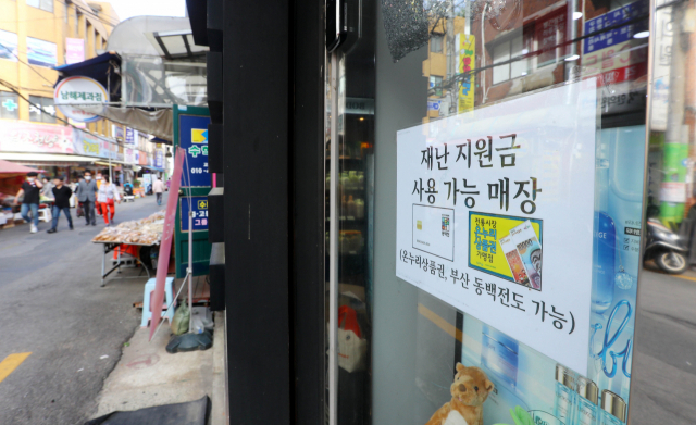 14일 부산 동구 수정동 수정시장 인근 상가에 긴급재난지원금 사용 가능을 알리는 안내문이 붙어 있다. 정종회 기자 jjh@