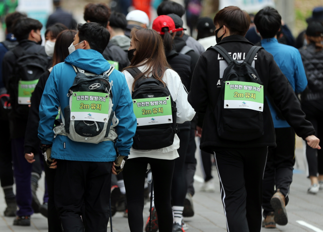 젊은 층의 등산 열풍이 거세다. 사진은 지난달 25일 북한산 국립공원에서 코로나19 감염병 예방 캠페인을 벌이고 있는 젊은 산악회 회원들의 모습. 연합뉴스