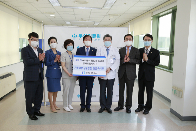 부산상공회의소가 25일 부산 연제구 부산의료원에서 코로나19 진료현장에 참여한 의료진에게 호텔 숙박권 등 선물을 전달하고 있다. 부산상의 제공