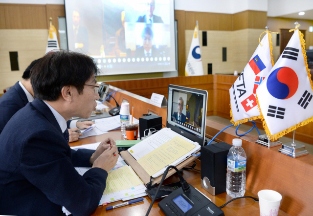 노건기 산업통상자원부 FTA정책관(수석대표)이 5일 세종시 정부세종청사 산업부 회의실에서 마르쿠스 슈라겐호프 EFTA 측 스위스 무역협정대사(수석대표)와 '제7차 한-EFTA FTA 공동위원회 화상회의'를 하고 있다. 산업부 제공