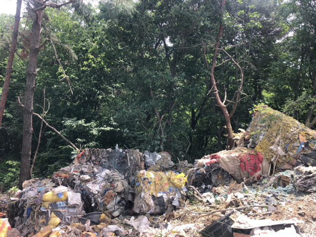 지난달 27일 한밤중에 충남지역에서 트럭으로 진주시 미천면 어옥리 야산에 버려진 산업폐기물 더미. 진주시 제공