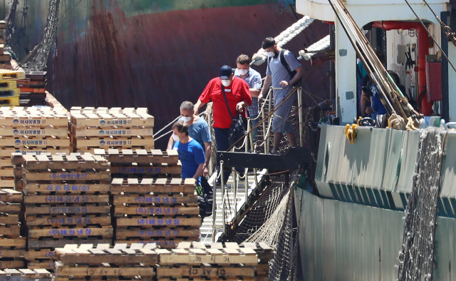 지난 23일 부산 감천항에 정박 중인 러시아 선박 아이스 스트림호에서 코로나19 확진 판정을 받은 선원들이 부산의료원으로 이송되고 있다.전날 이 선박 선원 21명 중 16명이 코로나19 양성 판정을 받은 데 이어 26일 나머지 5명 중 2명도 재검사 결과 확진됐다. 정종회 기자 jjh@