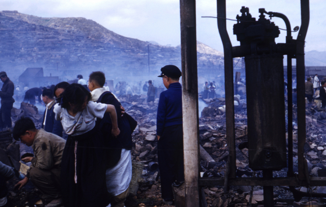 1954년 11월 부산 동구 범일동 미군 55보급창이 불탄 자리 모습입니다. 불에 탄 미군부대에서 혹시 돈 되는 거라도 찾을까 싶어서 저렇게 얼라까지 업고 잔해 속을 뒤지고 있는 겁니다. 부경근대사료연구소 제공