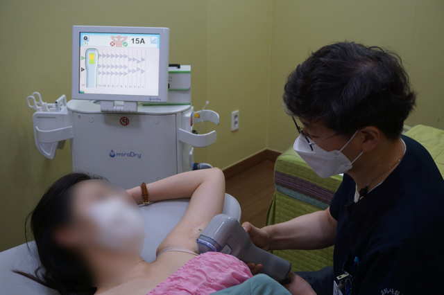 겨드랑이 땀샘과 냄새샘을 제거하기 위해 이흥렬 원장이 국소마취 후에 미라드라이 시술을 하고 있다. 남포고운피부과 제공