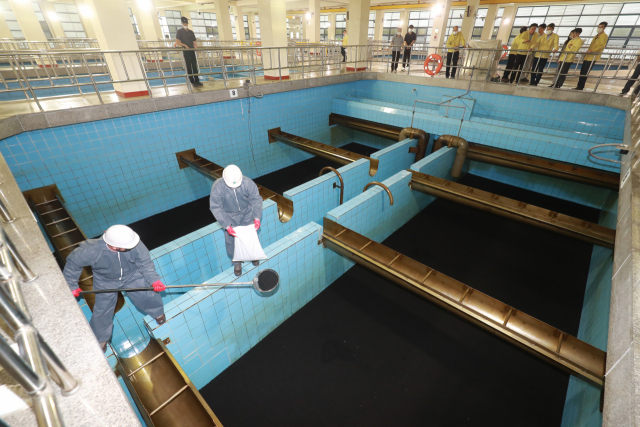 경남 김해시 대동면 덕산정수장에서 정수장 직원들이 활성탄 일부를 퍼내고 있다. 김경현 기자 view@