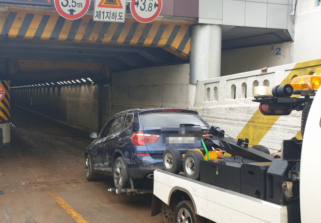24일 오전 전날 폭우로 지하차도가 침수되면서 차량 6대가 고립되고, 시민 3명이 숨진 부산 초량동 부산역 제1지하차도 사고 현장에서 침수된 차량을 견인하고 있다. 정대현 기자 jhyun@