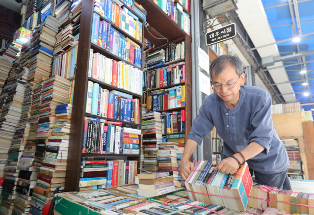 지난달 31일 책방골목을 찾아 얼마 안 남은 책 꾸러미를 옮기는 김종훈 대표. 김경현기자 view@