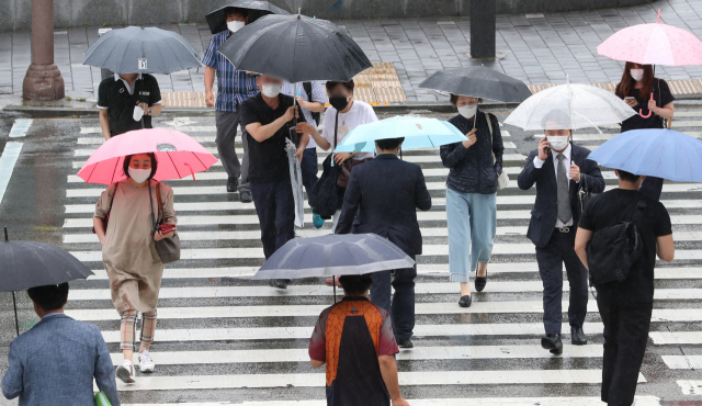 부·울·경 지역에 오는 8일까지 비가 예보됐다. 우산을 쓰고 부산역 앞 횡단보도를 지나는 시민들. 부산일보DB