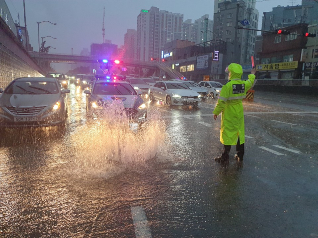 7일 오후 부산에 폭우가 쏟아지면서 가야굴다리 앞 맨홀이 역류해 교통이 통제되고 있다.