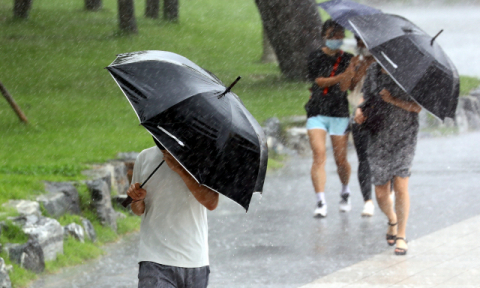 제5호 태풍 ‘장미’의 직접 영향권에 들어간 지난10일 오후 부산 해운대해수욕장을 찾은 관광객들이 거세진 비바람에 힘겹게 걸어가고 있다. 정종회 기자 jjh@