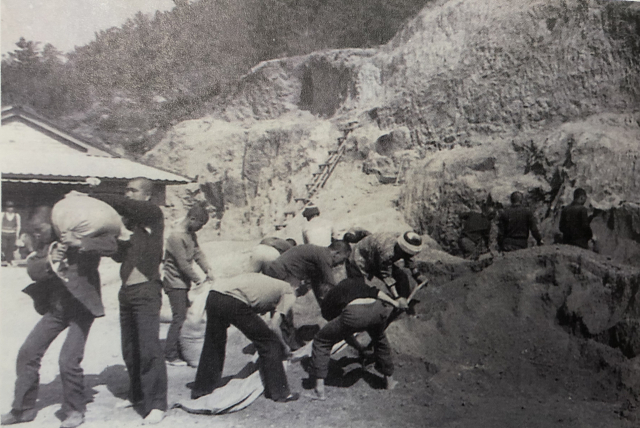 무거운 흙과 자갈 포대를 어깨에 메고 나르는 원생들. 형제복지원 운영자료집