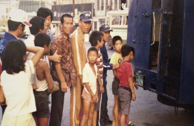 형제복지원 선도차량(파란 탑차)에 올라타는 사람들. 형제복지원 운영자료집