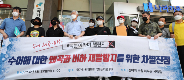 25일 오전 서울 중구 국가인권위원회 앞에서 시민단체 장애의벽을허무는사람들이 수어 왜곡과 비하 재발방지를 촉구하는 차별진정서를 인권위에 제출하기에 앞서 기자회견을 하고 있다. 의대생들이 정부 정책을 비판하기 위해 사용한 '덕분이라며 챌린지'의 손 모양은 '덕분에 챌린지'에 사용한 수어 '덕분에'를 뒤집어 사용한 것으로 이는 수어에 대한 왜곡과 비하라는 뜻을 밝혔다. 연합뉴스