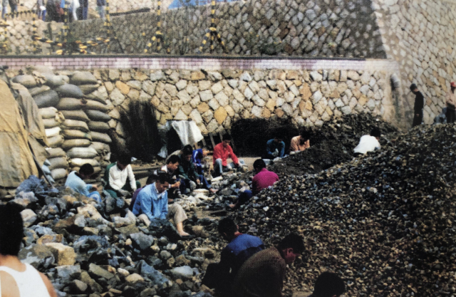 형제복지원 아래 하천에서 흙과 자갈을 져다 나르고 있는 원생들. 형제복지원 운영자료집