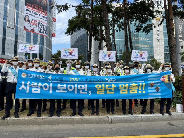 횡단보도를 걷던 한 보행자가 트럭에 치여 응급치료를 받고 있다. 아래는 부산 경찰이 안전 교통문화를 확산시키기 위해 실시한 ‘사람이 멈추면 일단 멈춤’ 교통 캠페인. 부산경찰청 제공