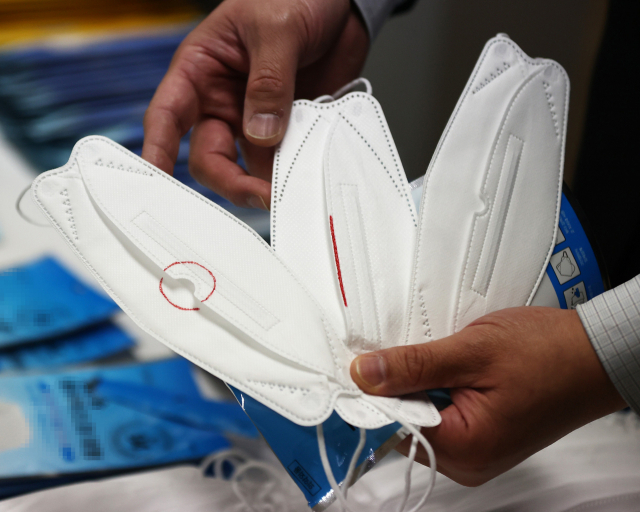 29일 양천구 서울지방식품의약품안전청에서 관계자가 적발된 무허가 KF94 마스크(가운데)에 대해 설명하고 있다. 적발된 A업체는 허가받지 않은 공장에서 마스크를 대량으로 생산한 후 허가받은 3개 업체로부터 포장지를 공급받아 포장해 납품하는 방식으로 무허가 보건용 마스크를 제조, 판매했다. 연합뉴스