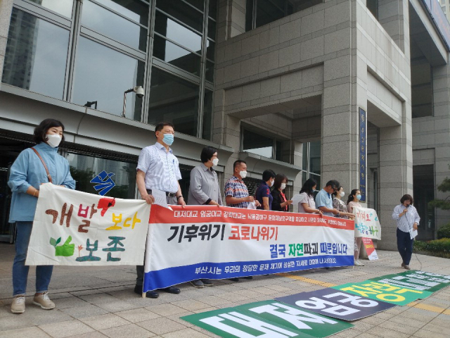 부산시가 식만~사상 간 도로 중 서낙동강 구간에 대한 환경영향평가 협의를 먼저 진행하는 등 착공 준비에 들어간다. 대저대교 투시도(위)와 올 6월 11일 부산시청 앞에서 열린 대저대교 환경영향평가 비판 기자회견. 부산일보DB