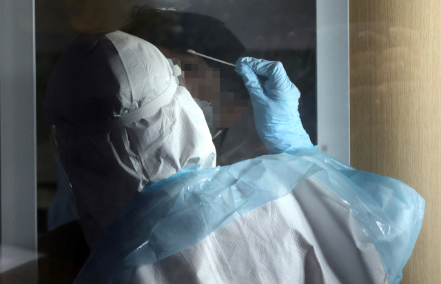17일 오후 서울 성동구보건소에 마련된 선별진료소에서 의료진이 검체를 채취하고 있다. 연합뉴스
