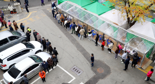 부산에서 코로나19 확진자가 22명 추가된 26일 부산 부산진구 보건소에 검진을 받으려는 시민들이 길게 줄을 서 있다. 정종회 기자 jjh@