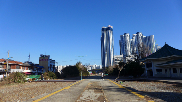 그린레일웨이 옛 해운대역 역사 부지는 아직 포장이 되지 않은 자갈길이다. 오른쪽 팔작지붕 건물이 옛 역사. 이 길을 건너 '해리단길'로 가는 사람들이 많다.