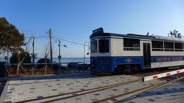 그린레일웨이 송정해수욕장을 지나 송정 승강장으로 들어서는 해운대블루라인파크의 해변열차. 신호음과 함께 차단기가 내려오는 옛 열차 건널목 풍경도 재현했다.