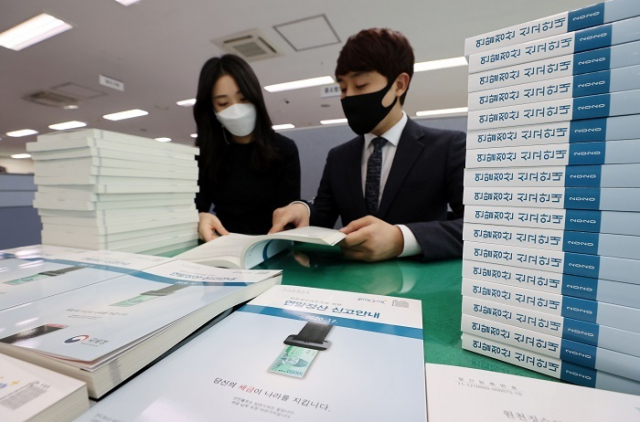 연말정산 소득·세액공제에 필요한 증명자료를 조회할 수 있는 홈택스 연말정산 간소화 서비스가 개통된 15일 개통됐다. 사진은 서울 종로세무서에서 직원들이 연말정산 안내 책자를 살펴보는 모습. 부산일보 DB