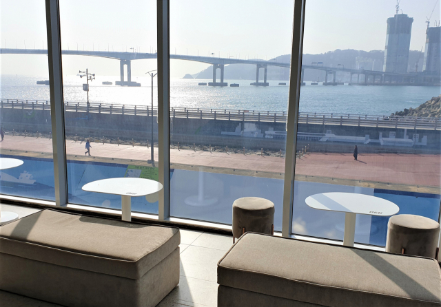 커피를 내리던 오구카페 오범철 대표가 잠시 포즈를 잡고 있다(위). 카페 테이블에서 내다보이는 남항대교와 바다풍경.