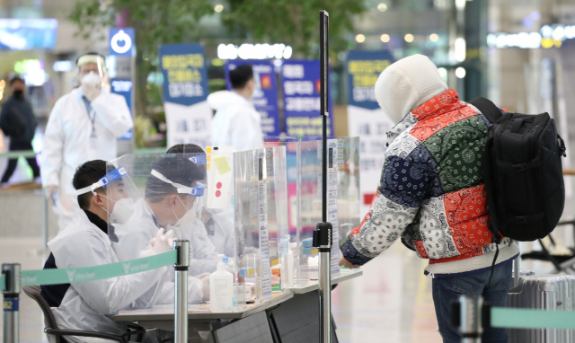 8일 오전 인천국제공항 제1터미널에서 한 해외입국자가 방역관계자의 안내를 듣고 있다. 연합뉴스