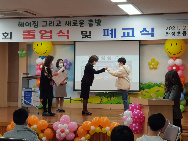 김호선 좌성초등 교장이 19일 오전 졸업생들에게 졸업장을 선사하고 주먹 악수를 하고 있다. 황석하 기자