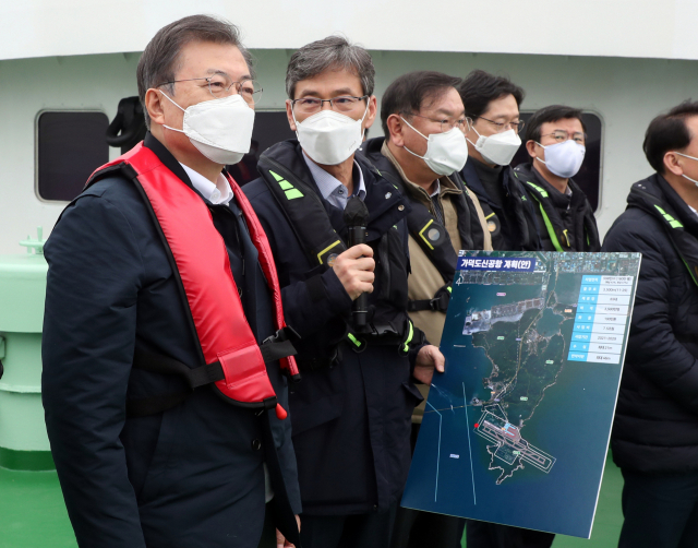 문재인 대통령이 25일 부산에서 열린 '동남권 메가시티 구축 전략 보고'에 참석, 가덕도 공항 예정지를 어업지도선을 타고 선상 시찰하며 이병진 부산시장 권한대행으로부터 관련 보고를 청취하고 있다. 연합뉴스
