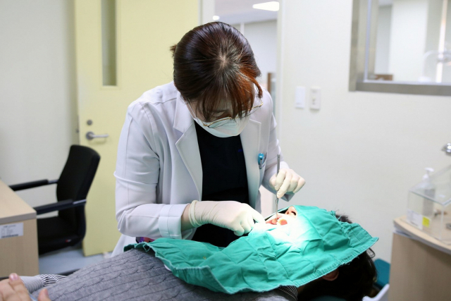 구내염이 2주 내에 사라지지 않으면 병원에서 진단받아 봐야 한다. 부산대치과병원 정성희 구강내과 교수가 구내염 환자를 시술하고 있다. 부산대치과병원 제공